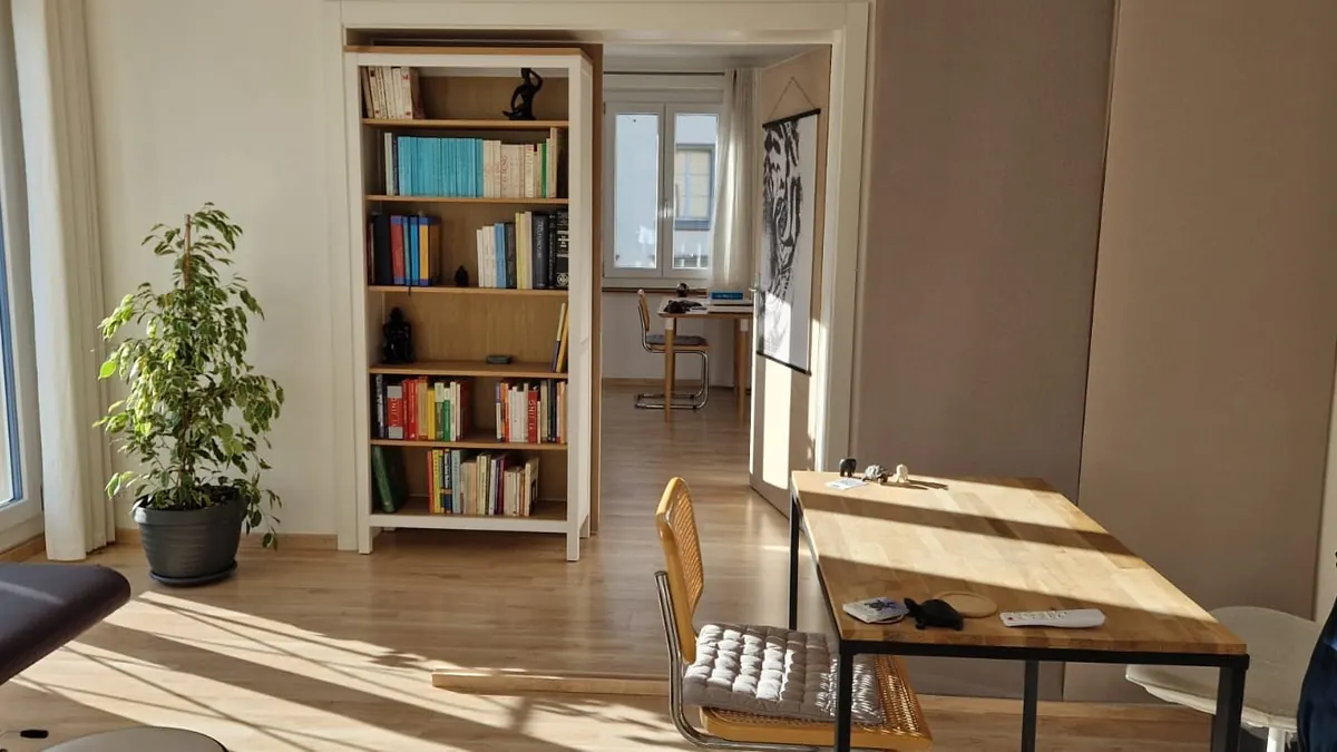 Espace d’entretien avec bibliothèque, plante et table en bois